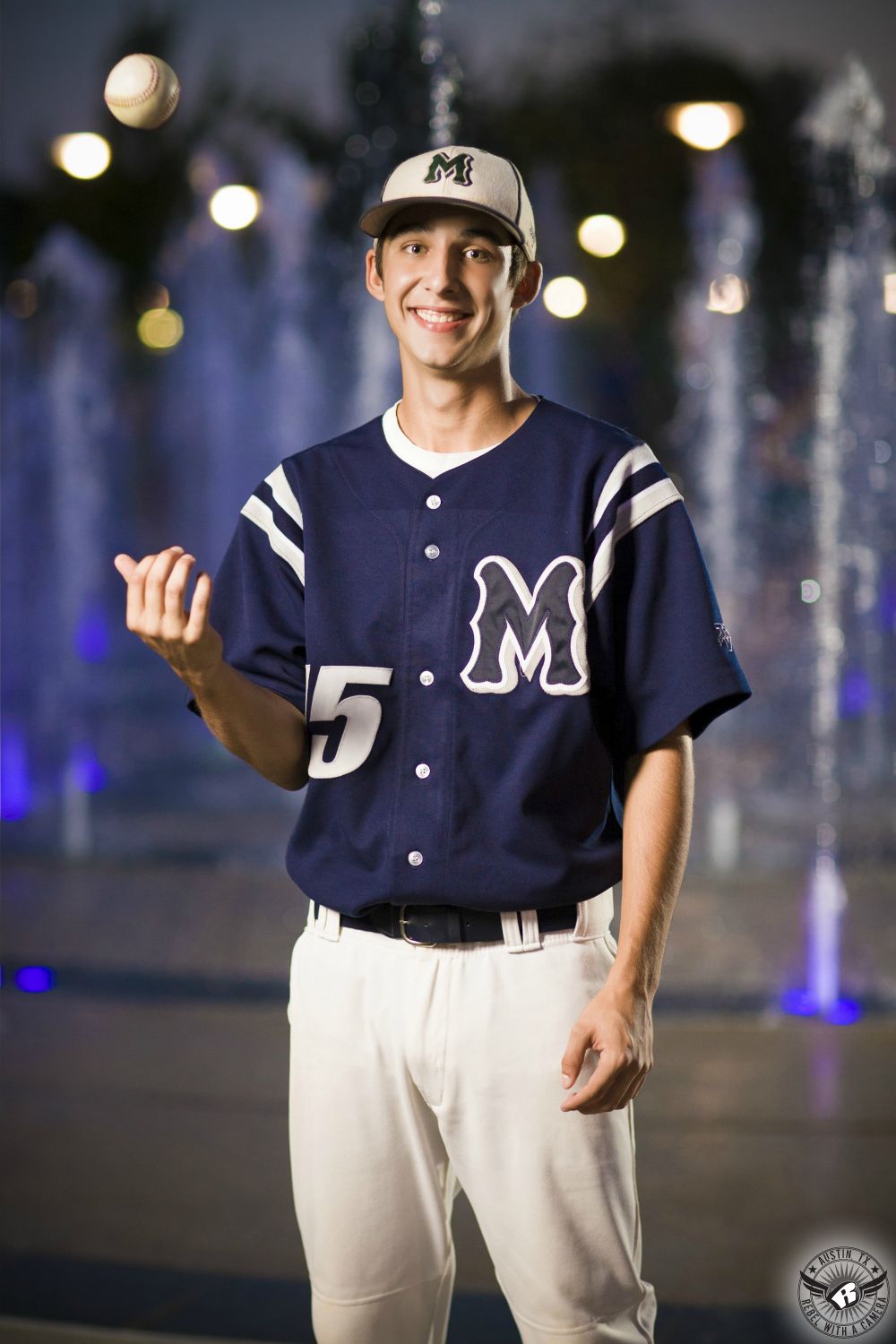 Baseball player high school senior portraits in Austin at the Liz Carpenter Fountain at Butler Park taken at night.